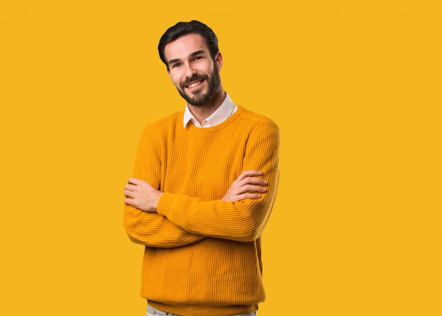 Jovem natural, cruzando os braços, sorrindo e relaxado