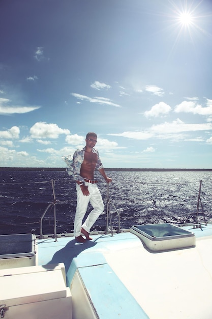 Jovem navegando em seu barco em mar aberto