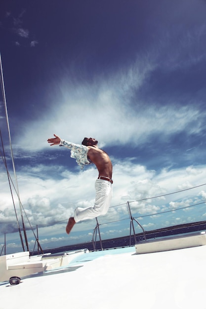 Foto jovem navegando em seu barco em mar aberto