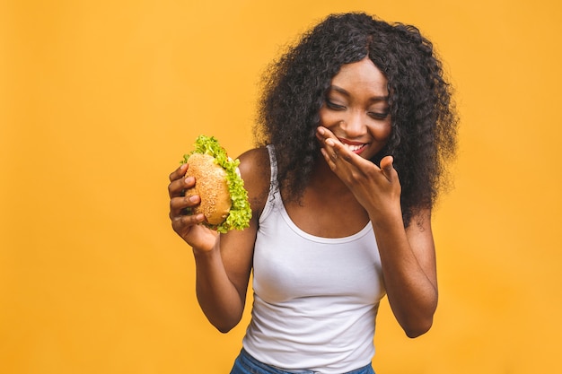 Jovem negra afro-americana comendo hambúrguer