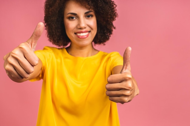 Foto jovem negra afro-americana isolada em fundo rosa dando um polegar para cima gesto