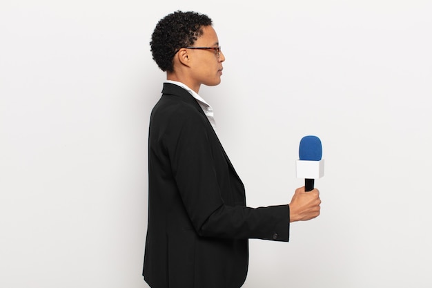 Foto jovem negra afro em vista de perfil, olhando para copiar o espaço à frente, pensando, imaginando ou sonhando acordada