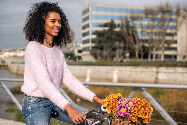 Jovem negra andando de bicicleta vintage