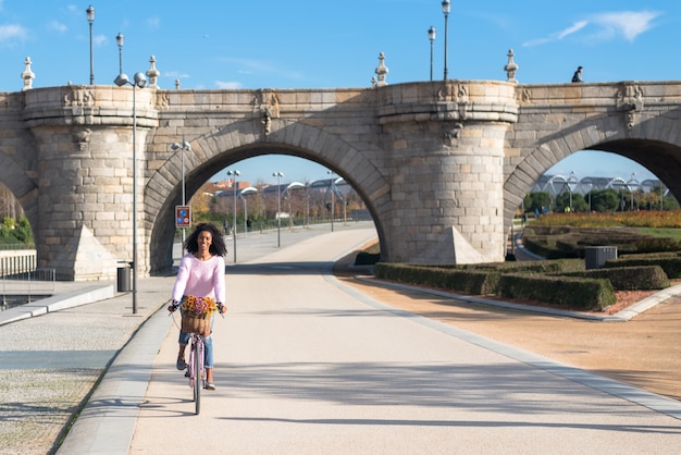 Jovem negra andando de bicicleta vintage