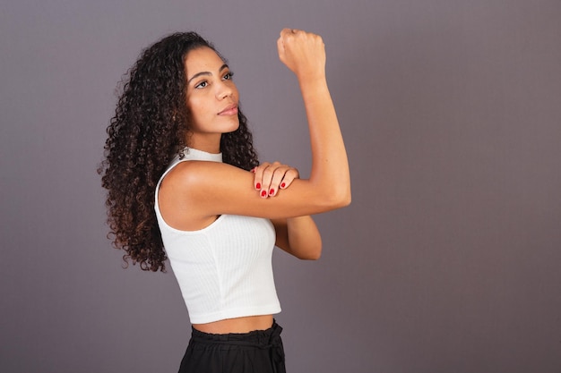 Jovem negra brasileira com feminismo de militância de punho levantado e fechado