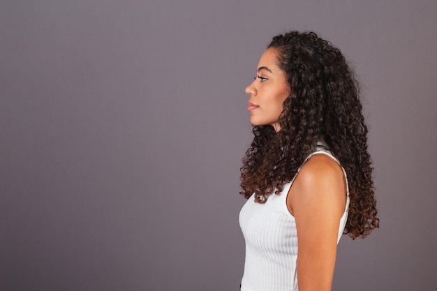 Jovem negra brasileira de perfil lateral olhando para a esquerda