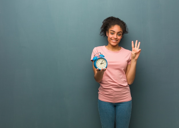 Jovem negra mostrando o número três