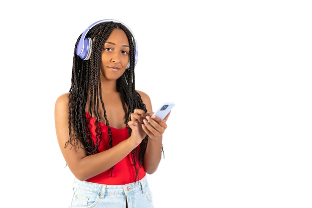 Jovem negra ouvindo música com seu telefone em um fundo branco