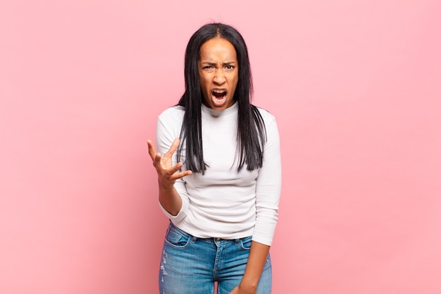 Jovem negra parecendo zangada, irritada e frustrada gritando wtf ou o que há de errado com você