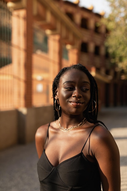 Jovem negra posando despreocupada com os braços atrás das costas na rua