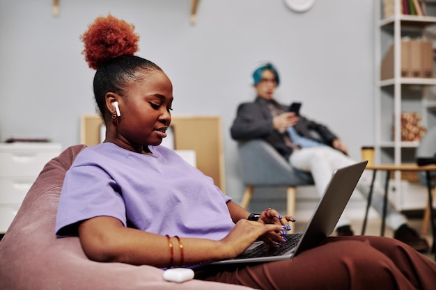 Jovem negra usando laptop na sala do escritório