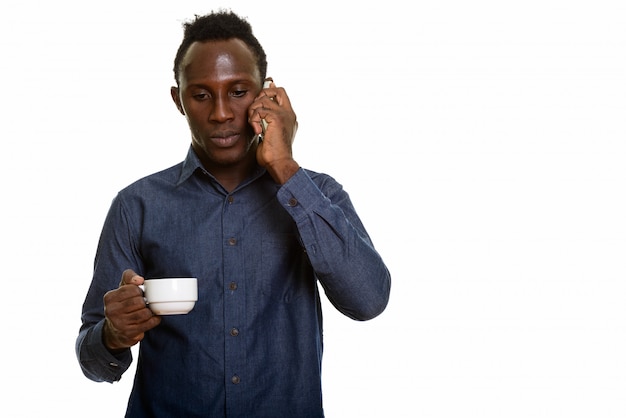 Foto jovem negro africano falando no celular enquanto segura o copo