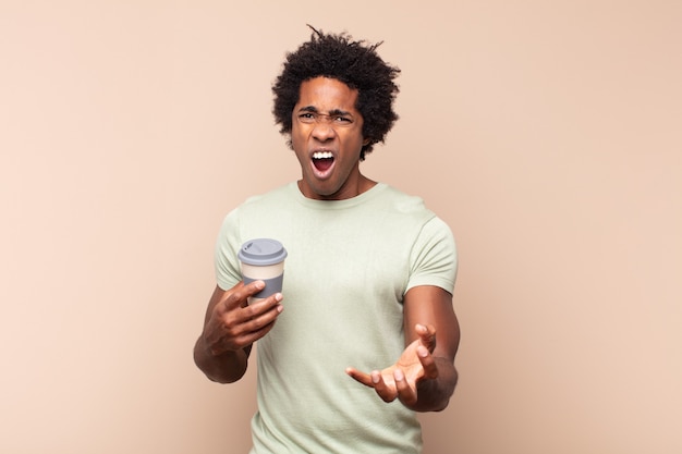 Jovem negro afro parecendo zangado, irritado e frustrado gritando wtf ou o que há de errado com você