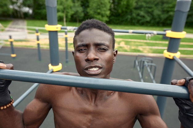 Jovem negro fazendo abdominais ao ar livre Ele está em um parque