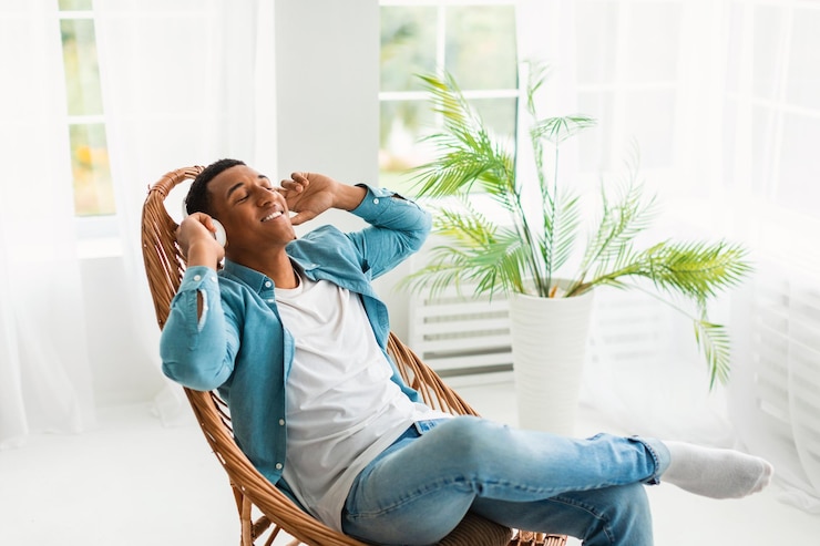 Foto jovem negro feliz com fones de ouvido sem fios desfruta de música favorita e tempo livre