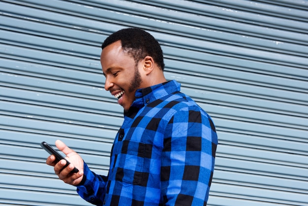 Jovem negro rindo com celular