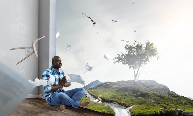 Jovem negro sentado e meditando. Mídia mista