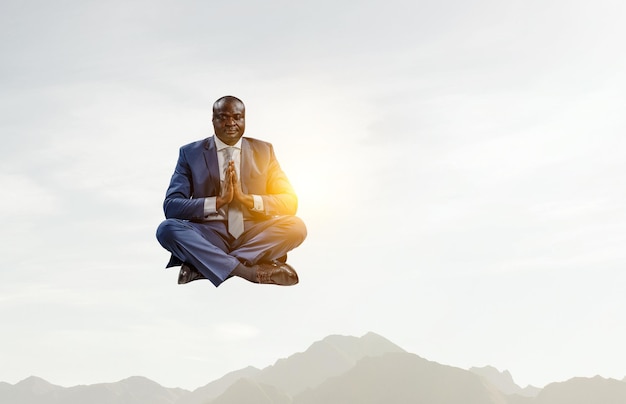 Jovem negro sentado e meditando. Mídia mista