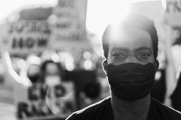 Jovem negro usando máscara facial durante protesto pela igualdade de direitos
