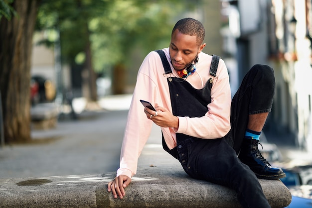 Jovem negro usando telefone inteligente ao ar livre