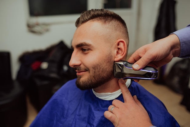 Jovem no conceito de serviço de cuidados com o cabelo de barbearia Foco seletivo Foto de alta qualidade