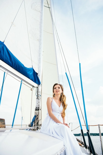 Foto jovem no convés do iate branco de madeira