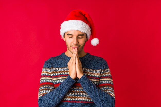 Jovem no dia de Natal, dobrando os lábios e segurando as palmas das mãos para enviar beijo de ar.