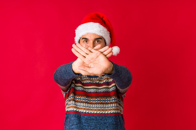 Jovem no dia de natal, sorrindo, mostrando alegre número cinco com os dedos.