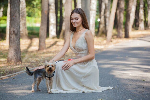 Jovem no parque com seu cachorro yorkshire terrier