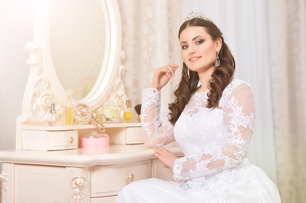 Jovem noiva linda em vestido branco posando