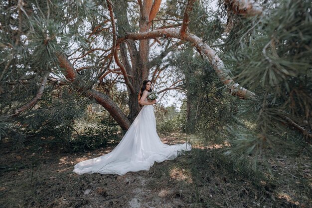 Jovem noiva luxuosa em um guarda-roupa caro e elegante posa para uma sessão de fotos de casamento em um resort de luxo