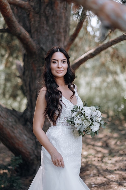 Jovem noiva luxuosa em um guarda-roupa caro e elegante posa para uma sessão de fotos de casamento em um resort de luxo