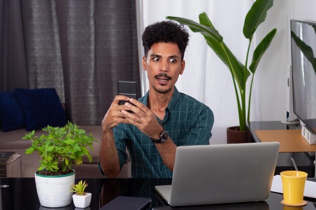 Jovem nômade em uma reunião de teletrabalho em uma mesa com um laptop