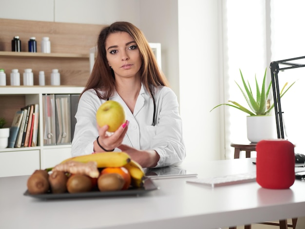 Jovem nutricionista feminina segurando a maçã