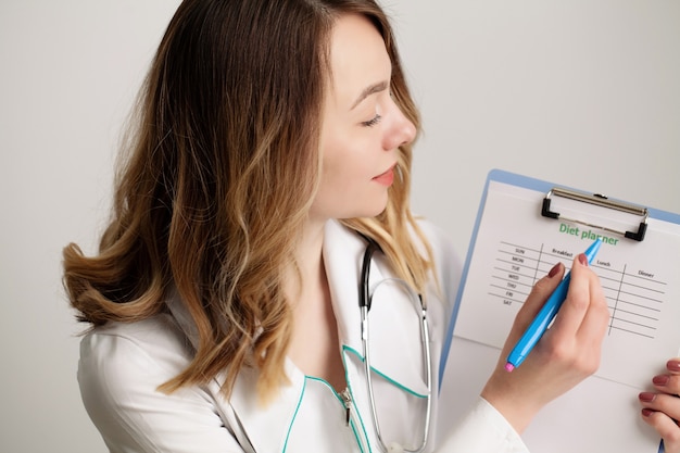 Foto jovem nutricionista médico escrevendo plano de dieta, alimentação saudável.