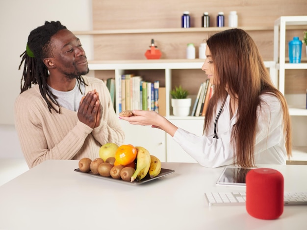 Jovem nutricionista no escritório sugere comer gengibre para seu paciente