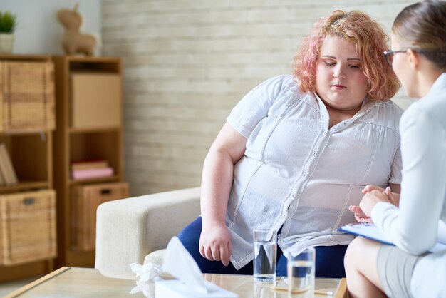 Jovem obesa falando com psiquiatra