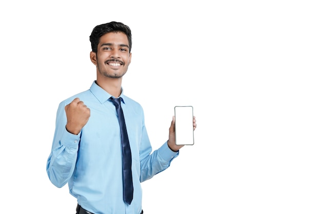 Jovem oficial indiano ou estudante mostrando a tela do smartphone em fundo branco.