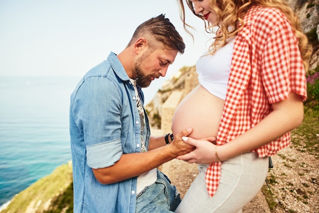 Jovem, olhando para a barriga da mulher grávida