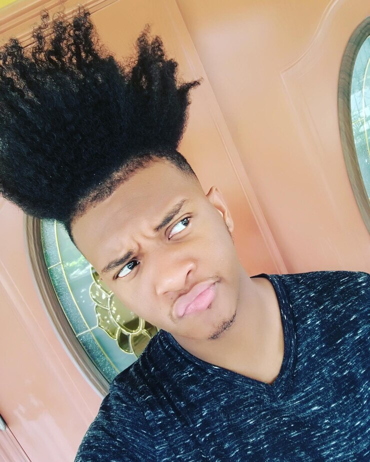Foto jovem olhando para longe enquanto está de pé contra a porta
