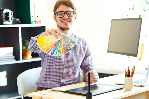 Foto jovem olhando para uma paleta de cores no escritório em casa