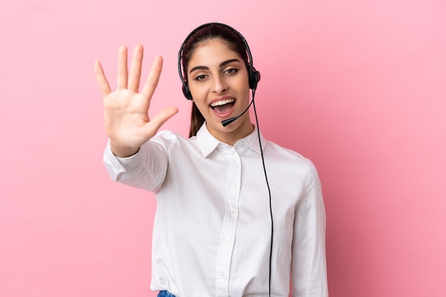 Jovem operador de telemarketing em fundo isolado, contando cinco com os dedos