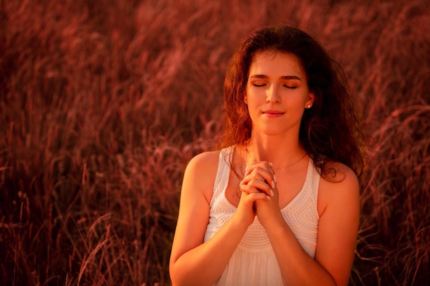 Jovem orando e silhueta de Jesus Cristo cruz contra o céu espiritualidade religião