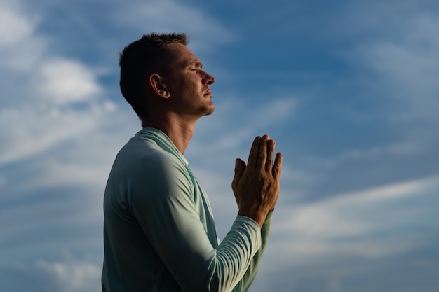 Jovem orar no fundo do céu azul religião fé e conceito de esperança