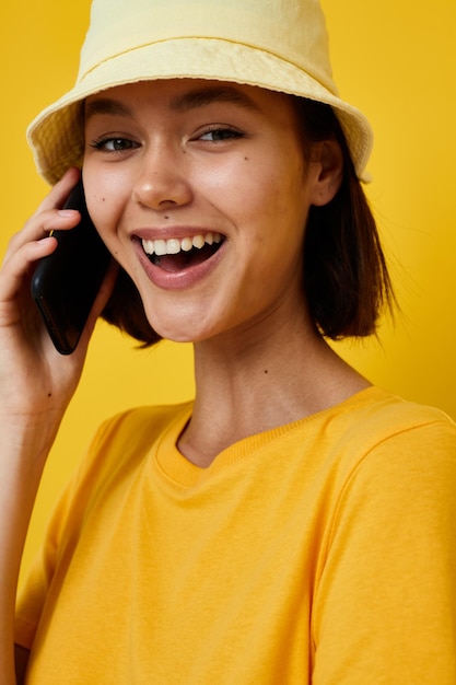 jovem otimista com um chapéu amarelo Estilo juvenil casual falando ao telefone Estilo de vida inalterado. Foto de alta qualidade