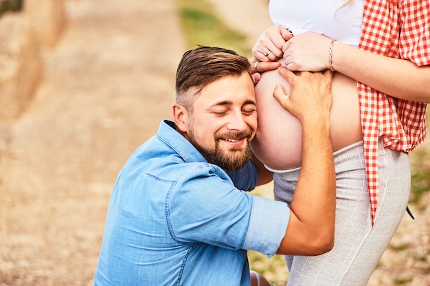 Foto jovem ouvindo a barriga da mulher grávida