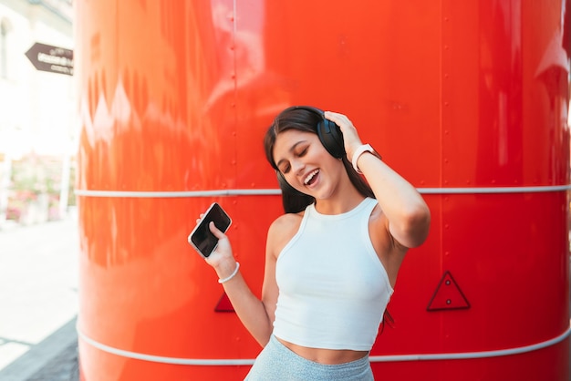 Jovem ouvindo música com fones de ouvido sem fio na rua