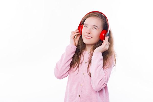 Jovem ouvindo música em fones de ouvido na parede branca