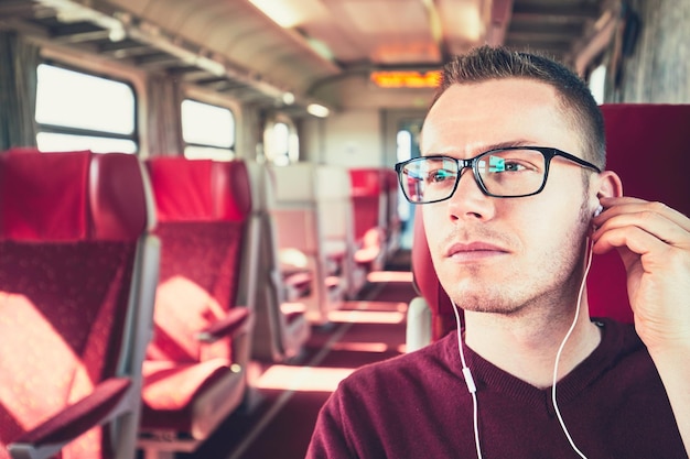 Foto jovem ouvindo música enquanto viaja de ônibus