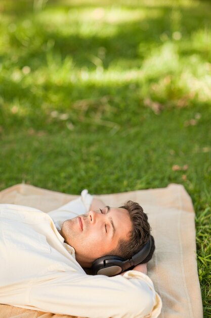 Foto jovem ouvindo música no parque